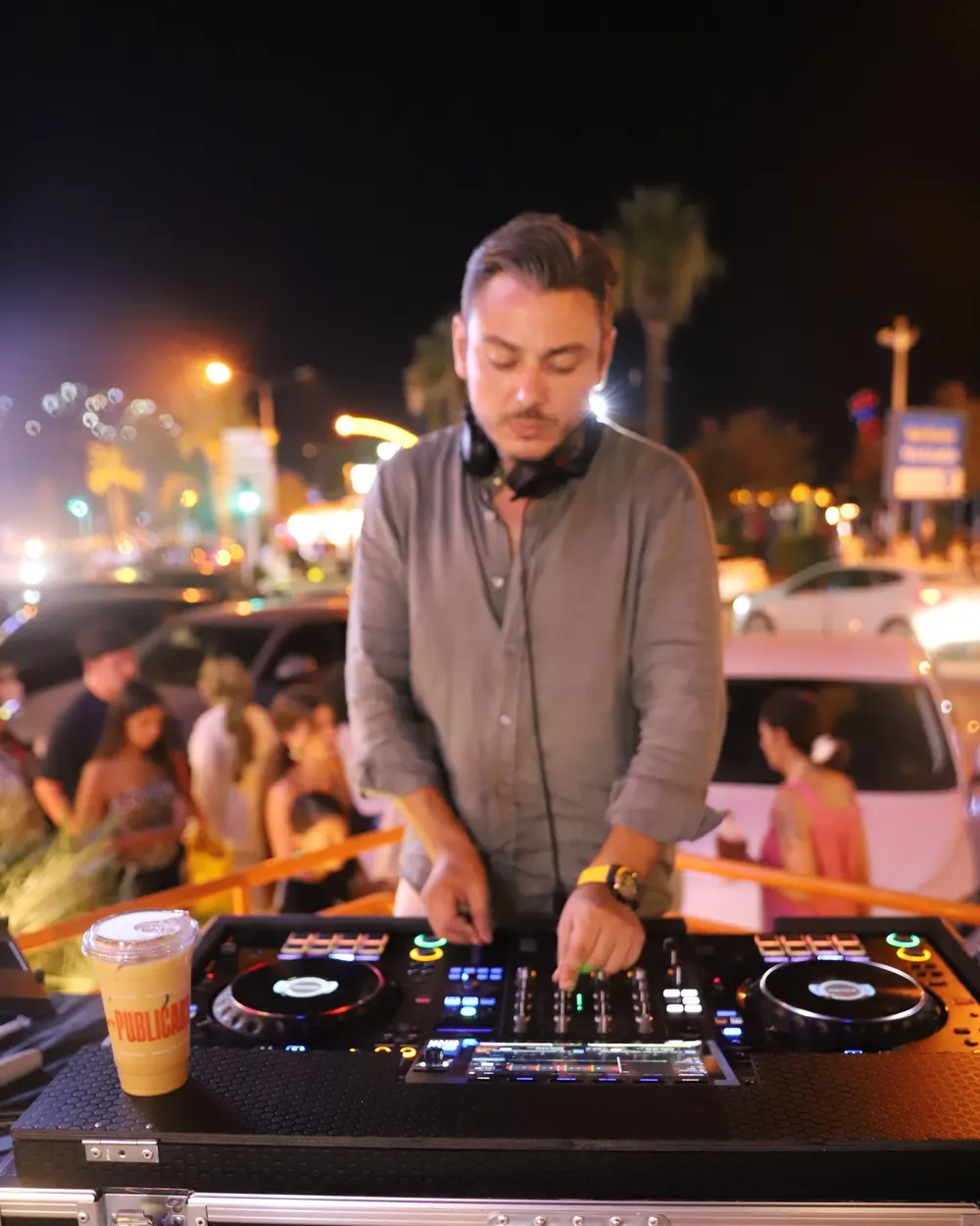 Sahil yolunda DJ performansı, masada Public bardak